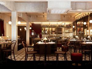 a restaurant with tables and chairs and a bar at Navera Phuket - MGallery Collection in Surin Beach