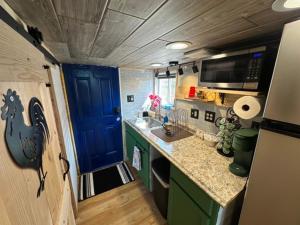 a small kitchen with a blue door and a sink at Tiny House Farm Stay Pets Welcome in Battle Ground +4 photos