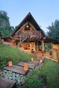 a large wooden house with wooden steps in front of it at Batukaru Coffee Estate in Tabanan +40 photos