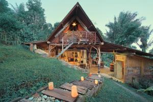 a log cabin with benches in front of it at Batukaru Coffee Estate in Tabanan