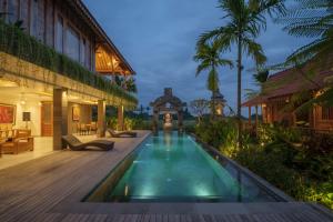 a pool in the middle of a house with a wooden deck at Jero Jawi Javanese Villa in Lebih