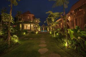 a courtyard of a house at night with lights at Jero Jawi Javanese Villa in Lebih +13 photos
