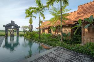 a villa with a swimming pool in front of a house at Jero Jawi Javanese Villa in Lebih