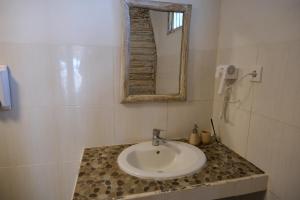 a white bathroom with a sink and a mirror at Jungle Gili Air in Gili Islands +55 photos
