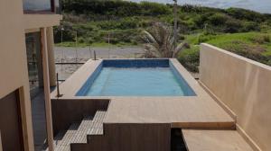 a swimming pool with stairs and a house at Coral Loft in Antón Lizardo +18 photos