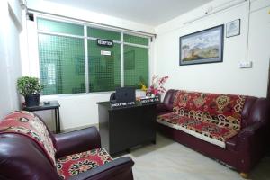 a living room with two leather couches and a table at Himavati Retreat in Darjeeling