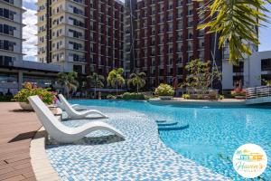 a swimming pool with two chairs and some buildings at Haven's Villa in Agus