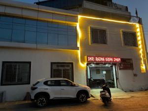 a white car parked in front of a building at Shri Radha Kripa Dham in Rādha Kund