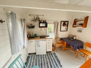 a kitchen and dining area of a tiny house at Historic Cabin By Landsort Lighthouse in Nynäshamn