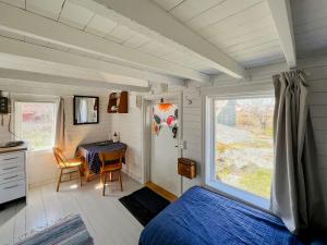 a room with a bed and a table and a window at Historic Cabin By Landsort Lighthouse in Nynäshamn