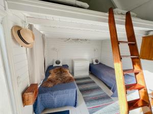 a small bedroom with two beds and a ladder at Historic Cabin By Landsort Lighthouse in Nynäshamn