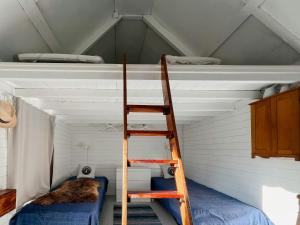 a ladder in a room with a attic at Historic Cabin By Landsort Lighthouse in Nynäshamn +5 photos