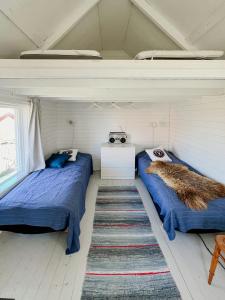 two beds sitting in a room with at Historic Cabin By Landsort Lighthouse in Nynäshamn