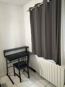a bedroom with a bed and a desk and a curtain at Chambre privée - Près de Bordeaux in Villenave-dʼOrnon