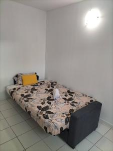 a bed in a white room with a bedspread on it at Chambre privée - Près de Bordeaux in Villenave-dʼOrnon