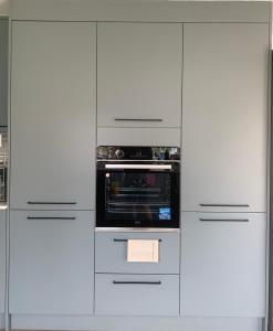 a kitchen with white cabinets and a microwave at Bushy Hill Drive in Guildford in Guildford