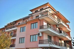 ein rosafarbenes Gebäude mit Balkon an der Seite in der Unterkunft Panorama Apartment in Welingrad