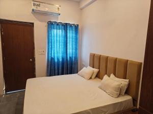 a bedroom with a bed with a blue curtain at Sunrise stay in Mathura