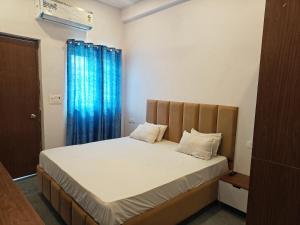 a bedroom with a bed with a blue curtain at Sunrise stay in Mathura