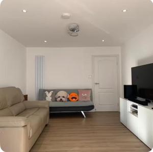 a living room with a couch and a flat screen tv at Bushy Hill Drive in Guildford in Guildford