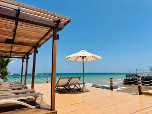 a wooden deck with chairs and an umbrella on the beach at BaanRabiangnam kohlarn in Ko Larn
