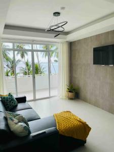 a living room with a couch and a large window at OcamOcam Sunset-Bay Guest House in Busuanga