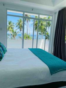a bedroom with a bed with a view of the beach at OcamOcam Sunset-Bay Guest House in Busuanga +42 photos