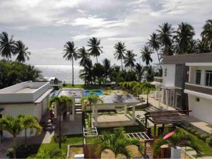 an aerial view of a house with a swimming pool and the ocean at OcamOcam Sunset-Bay Guest House in Busuanga