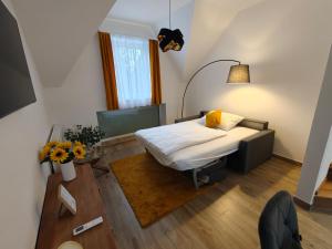 a small room with a bed and a table at Harmónia Apartmanház in Kőszeg