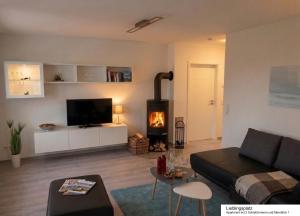 a living room with a couch and a fireplace at Ferienhaus Strandläufer in Langballig