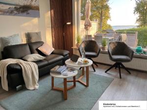 a living room with a couch and two chairs at Ferienhaus Strandläufer in Langballig