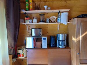 a shelf with a coffee maker and a coffeemaker at Chalet Glamping in Myza Igaste