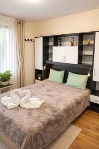 a bedroom with a large bed with towels on it at Pomorie Sea&History Residence in Pomorie