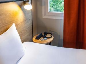 a bedroom with a bed and a wooden table with a plate with a pair at ibis Metz Centre Cathedrale in Metz