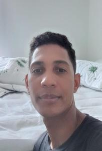 a man sitting on a bed smiling at the camera at Cabana do paraíso in Maragogi