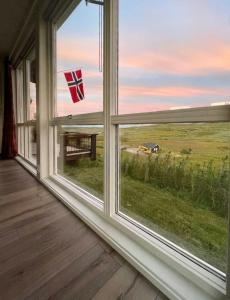 a window with a view of a table and a flag at Renovated Mountain Cabin With Mountain Views in Al