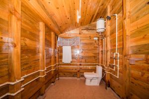 a bathroom with a toilet in a wooden cabin at Forest Rest House Satobari in Dharamshala