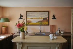 a kitchen with a sink and a painting on the wall at A Historic Gem With Wellness Comfort in Übersee