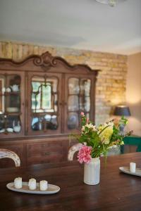 a wooden table with a vase of flowers and candles at A Historic Gem With Wellness Comfort in Übersee