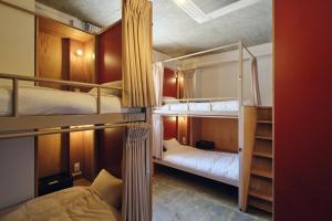 ein Zimmer mit zwei Etagenbetten in einem Zimmer in der Unterkunft Arbor Onomichi in Onomichi