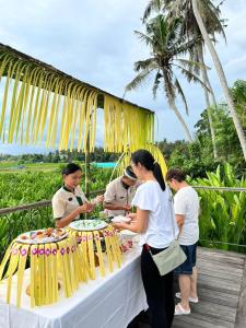 a group of people standing around a table at The Valerian Villa Ubud in Ubud