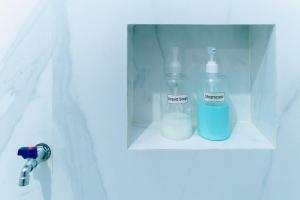 two glass bottles sitting on a shelf in a bathroom door at Luchis HOME Ijen in Banyuwangi