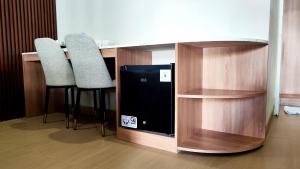 a kitchen with two stools and a counter with a microwave at Nio Garden Hotel in Sumbawa Besar