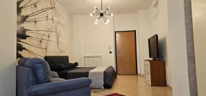 a bedroom with a blue couch and a bed and a television at Viale Umberto Apartments in Sassari
