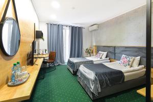 a hotel room with two beds and a flat screen tv at Villa Rosa in Timişoara