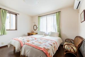 a bedroom with two beds and a window at Private Inn Ray in Nara