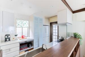 a kitchen with white cabinets and a wooden counter top at Private Inn Ray in Nara