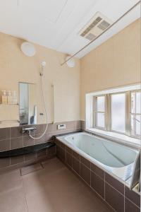 a large bathroom with a tub and a window at Private Inn Ray in Nara