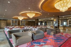 a banquet hall with tables and chairs and chandeliers at Clarks Inn Bokaro in Bokāro