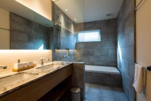 a bathroom with two sinks and a tub and a shower at Shion - 森音 in Kutchan